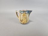 a blue and yellow pitcher sitting on a white surface