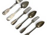 six forks and spoons are arranged in a row on a white surface