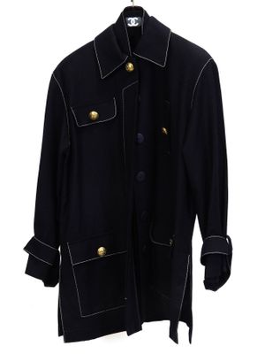 un manteau noir sur un cintre, sur fond blanc