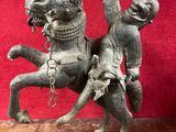 une statue représentant un homme à cheval posée sur une table en bois