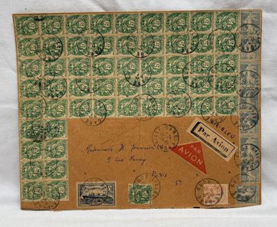 une vieille enveloppe sur laquelle sont apposés des timbres, posée sur une surface blanche