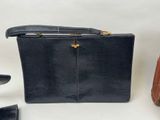 black leather purse with gold hardware and a pair of black shoes