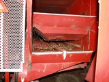a picture of a red machine with hay inside of it