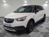 L'Opel blanche est garée dans une grande pièce au sol carrelé en damier.