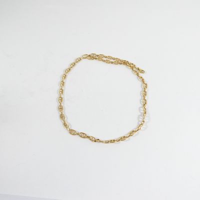 un bracelet en chaîne dorée sur un fond blanc
