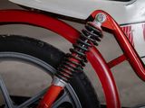 a close up of a red and white motorcycle with a black tire