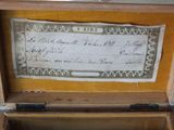 an old wooden box with a note inside of it