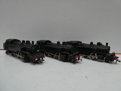 trois petits trains posés sur une surface blanche