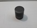 a close up of a black plastic knob on a white surface