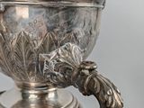 a silver bowl with a handle on a stand