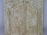 une image représentant un meuble en bois à deux portes, ornées de sculptures