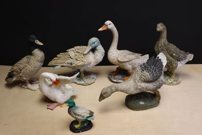 plusieurs figurines de canards posées sur une table en bois