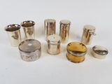 a group of silverware including cups and spoons on a white surface
