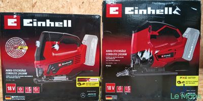 deux cartons contenant des tronçonneuses électriques posés sur une surface en bois