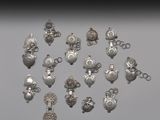 un assortiment de breloques et de pendentifs en métal argenté sur un fond gris
