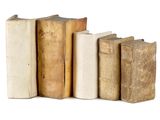 several old books are lined up in a row on a white surface