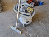 un aspirateur posé sur le sol à côté d'autres objets