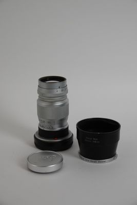 un objectif d'appareil photo posé à côté d'une tasse sur une table