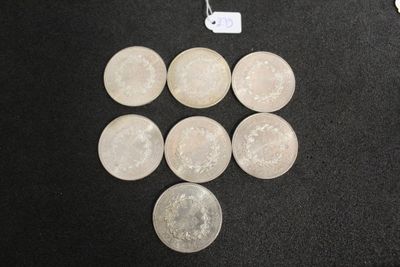 Plusieurs pièces d'argent sont disposées en triangle sur une surface noire