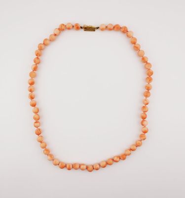 an orange beaded necklace on a white background