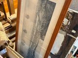 a pile of framed pictures on a table in a room