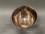 a silver bowl with a chain hanging from it