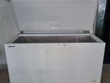 a white chest freezer sitting on a tiled floor
