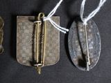three antique metal items are displayed on a black surface