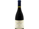 the bottle of wine is sitting on a white surface