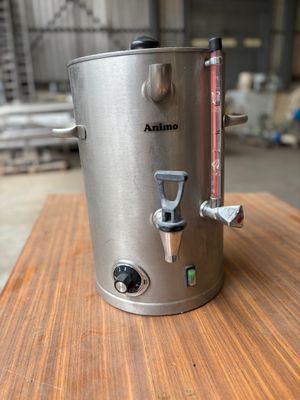 une casserole en acier inoxydable avec une poignée, posée sur une table en bois