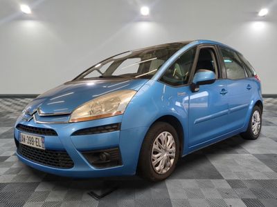 the small blue car is parked on a checkered tile floor