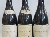 three bottles of wine are lined up on a white surface