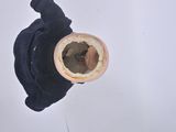 a small cup with a hole in it sitting on a table