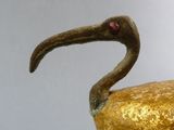 a gold bird with a red eye on it ' s head