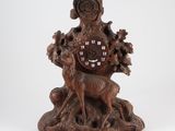 an image of a wooden clock with a deer and a bird on it