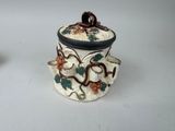 two ceramic containers with grapes on them on a table