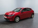 Une voiture rouge est garée dans une pièce aux murs blancs.