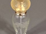 a small glass bottle with a gold lid on a gray surface