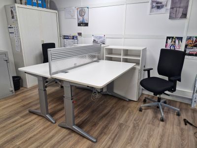 un bureau blanc avec une chaise noire dans une pièce