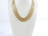 a close up of a mannequin wearing a gold chain necklace