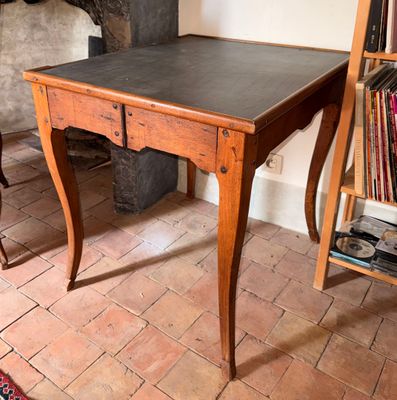 une table en bois avec un plateau noir dans une pièce