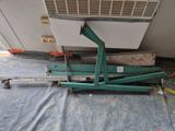 a green machine that is sitting on a blue tarp