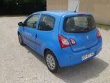 a small blue car parked in front of a building