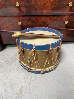 a drum that is sitting on the floor next to a dresser