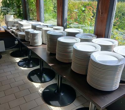 une longue table sur laquelle sont disposées de nombreuses assiettes, dans un restaurant