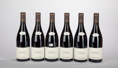 six bottles of wine lined up in a row on a table