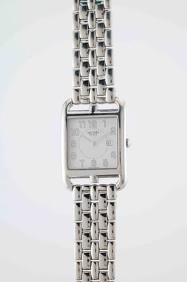 a silver watch that is sitting on a table