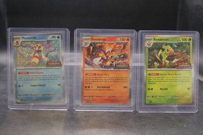 three different pokemon cards in plastic cases on a table
