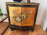 a small cabinet with flowers and birds painted on it