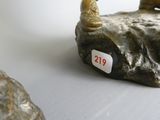 une statue représentant un homme assis sur un rocher